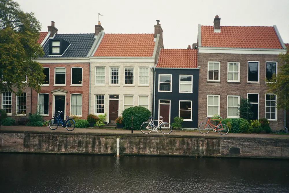 Bakstenen grachtenhuizen met pannendaken langs een gracht met fietsen
