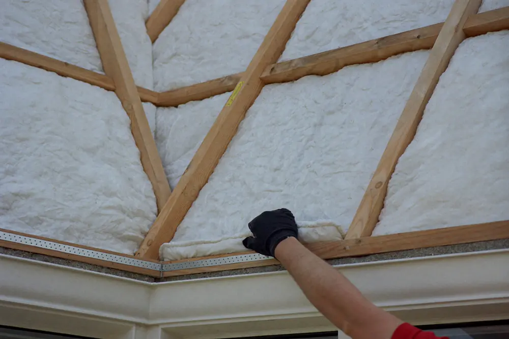 Isolatieplaten tussen houten stijlen in de wang van een dakkapel in aanbouw